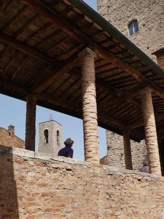 Man looking up to medieval tower San Gimignano